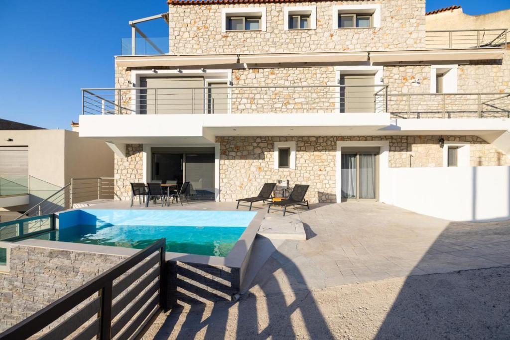 a villa with a swimming pool in front of a house at Villa Nazar in Xiropigado