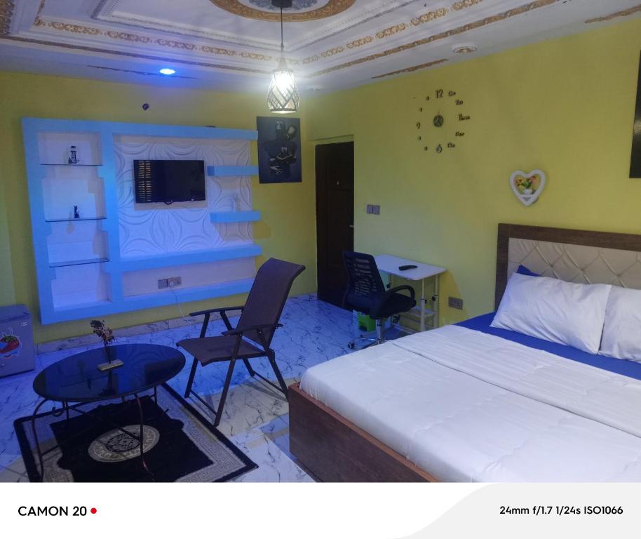 a bedroom with a bed and a table and a desk at RichRoyal Hotels Ltd in Oruama