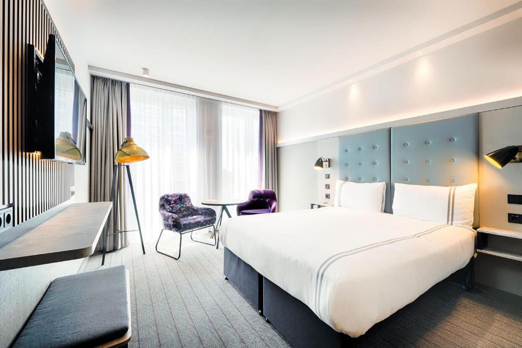 a hotel room with a large bed and a desk at Premier Inn Berlin Alexanderplatz in Berlin