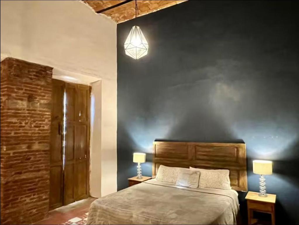 a bedroom with a bed and a blue wall at Canteira Boutique Aparthotel in Guanajuato