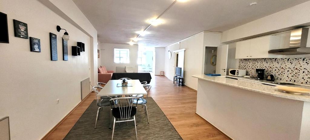 a kitchen and a living room with a table in a apartment at Driopon Apartment - Penthouse in Athens
