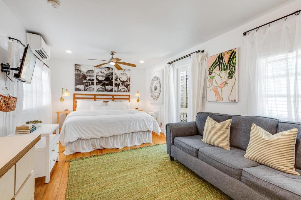 a white bedroom with a bed and a couch at HIDEAWAY @ Speakeasy Inn Key West! in Key West