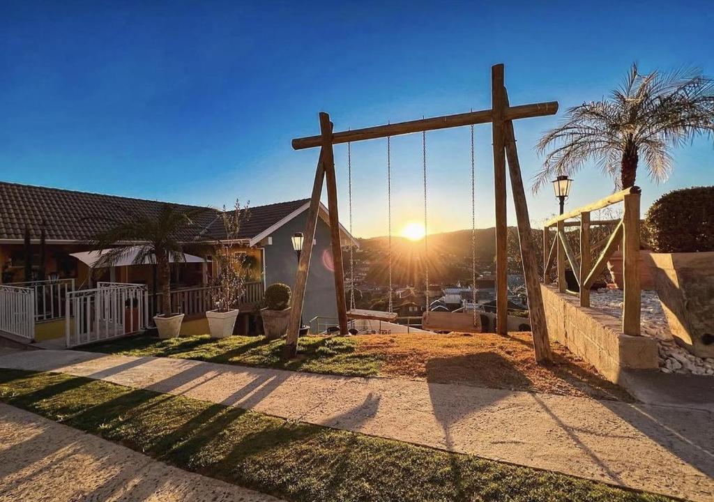 a wooden cross in a yard with a swing at Pousada Geada de Campos in Campos do Jordão