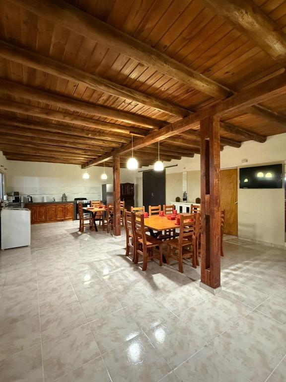 a kitchen and dining room with wooden tables and chairs at Refugio del Alma in Villa Anizacate