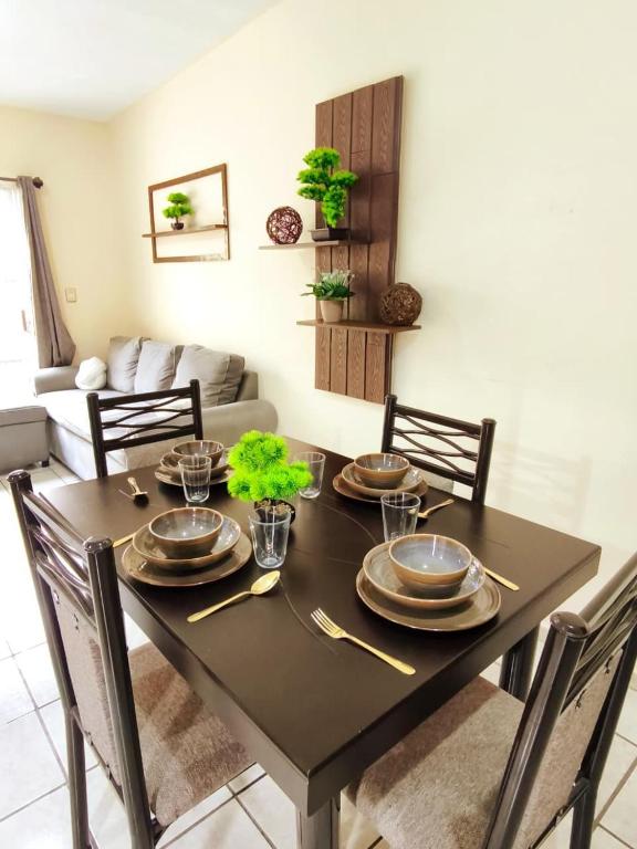 a dining room table with plates and utensils on it at Bonsai House in Ramos Arizpe