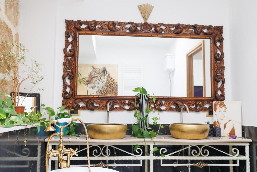 a mirror on top of a dresser with plants at Ire' Luxury Suite in Avola