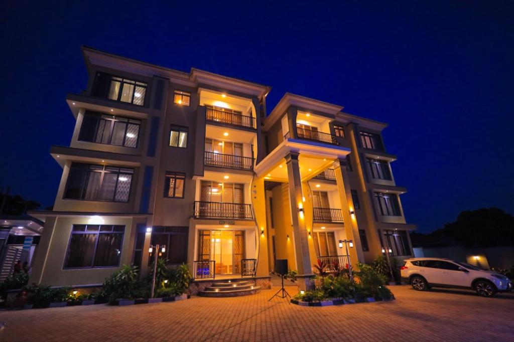 a building with a car parked in front of it at night at Taye Apartments in Entebbe