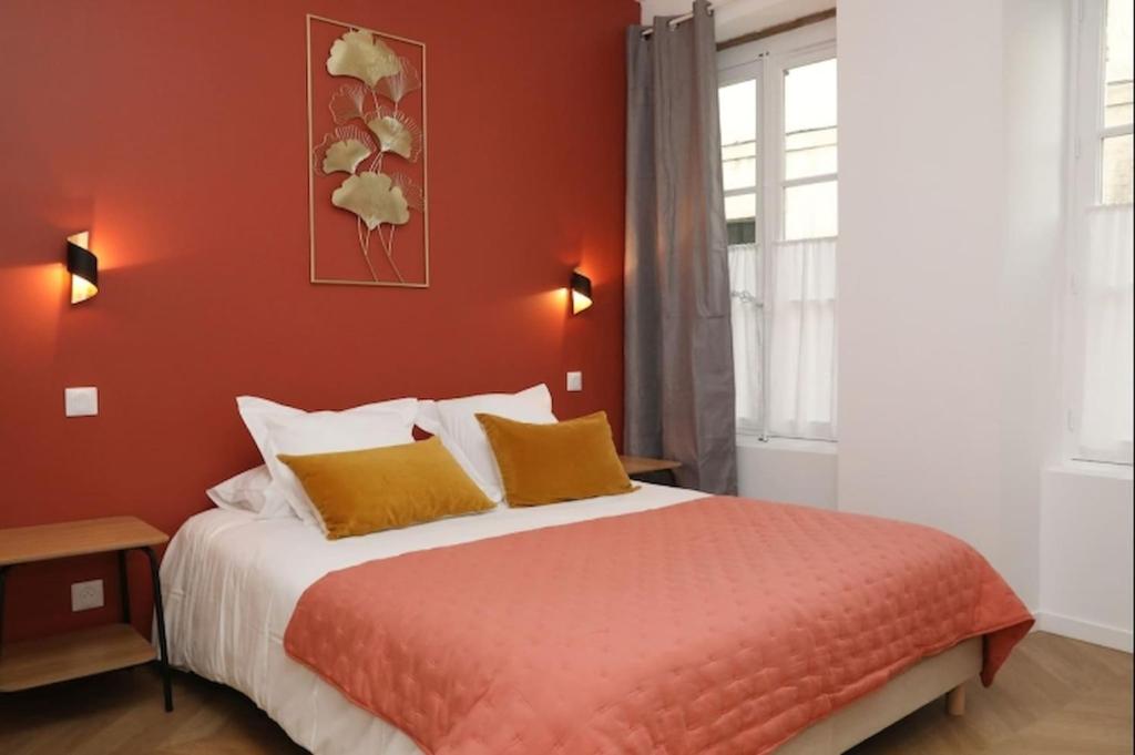 a bedroom with a large bed with orange walls at Notre Dame de Senlis by La boite en Plus in Senlis