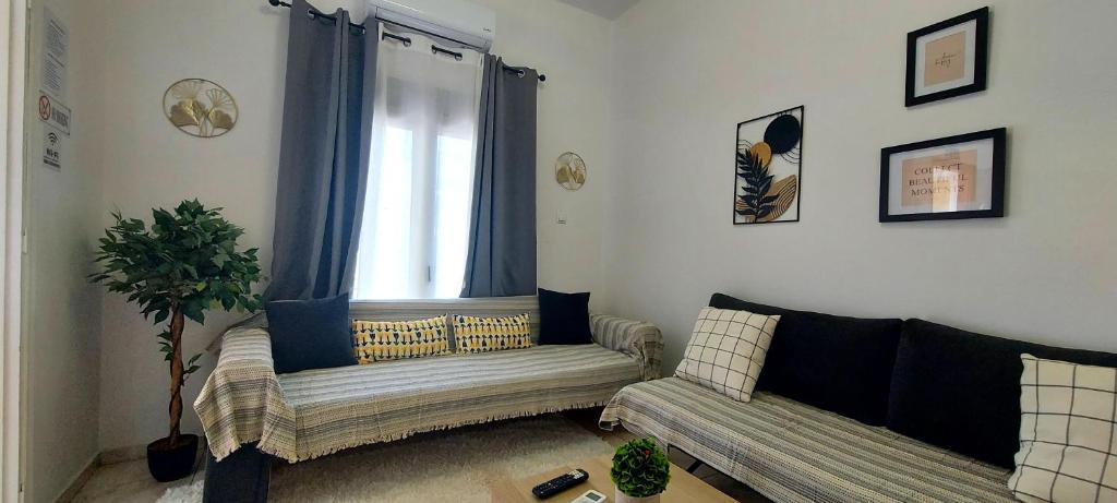a living room with two couches and a window at Diamond apartments in Artemida