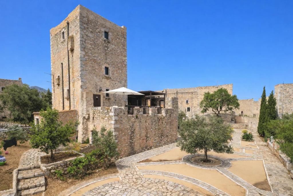 an old stone building with trees in front of it at Fameliti Casa Torre - Historic Maniot Tower House in Stavríon