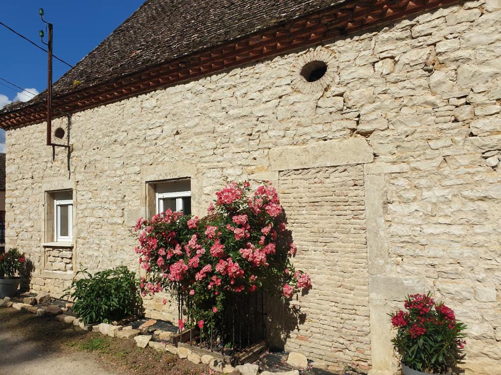 a stone building with flowers in front of it at Gîte L'échappée Bleue in Saint-Germain-du-Plain