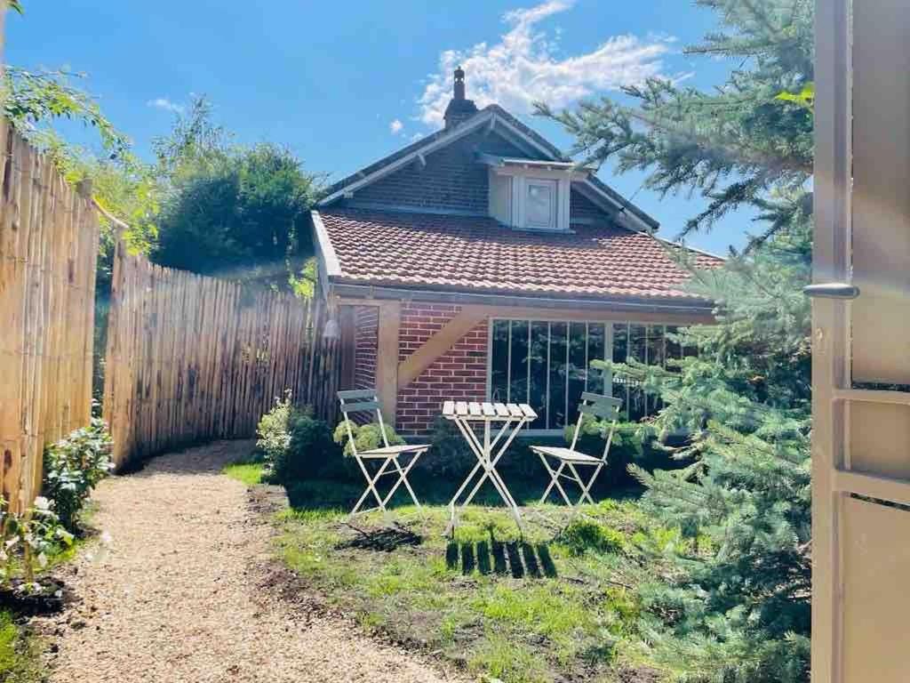 a small garden with two chairs and a fence at Suite Garden by La Boîte En Plus in Senlis