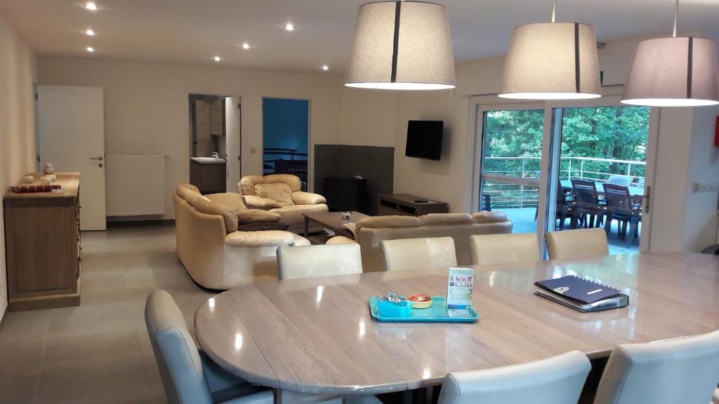 a dining room and living room with a table and chairs at Chalet Jarte in Barvaux