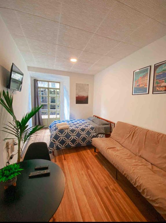 a living room with a couch and a bed at Cossy studio apartment in downtown in Cuenca