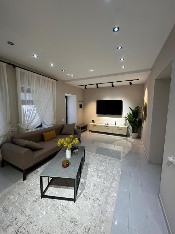 a living room with a couch and a tv at White Apartment in Baku