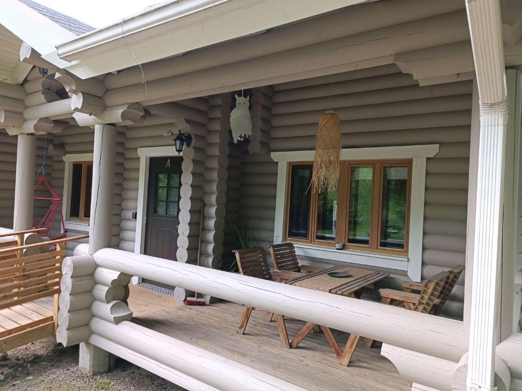 a porch of a house with chairs and a surfboard at Kolilla oy, Purnutar A in Kolinkylä