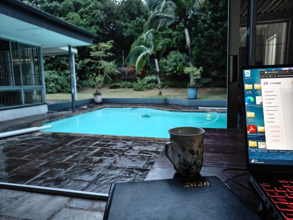 a laptop computer sitting on a table next to a swimming pool at Turtle Sands Holiday Home in Richards Bay