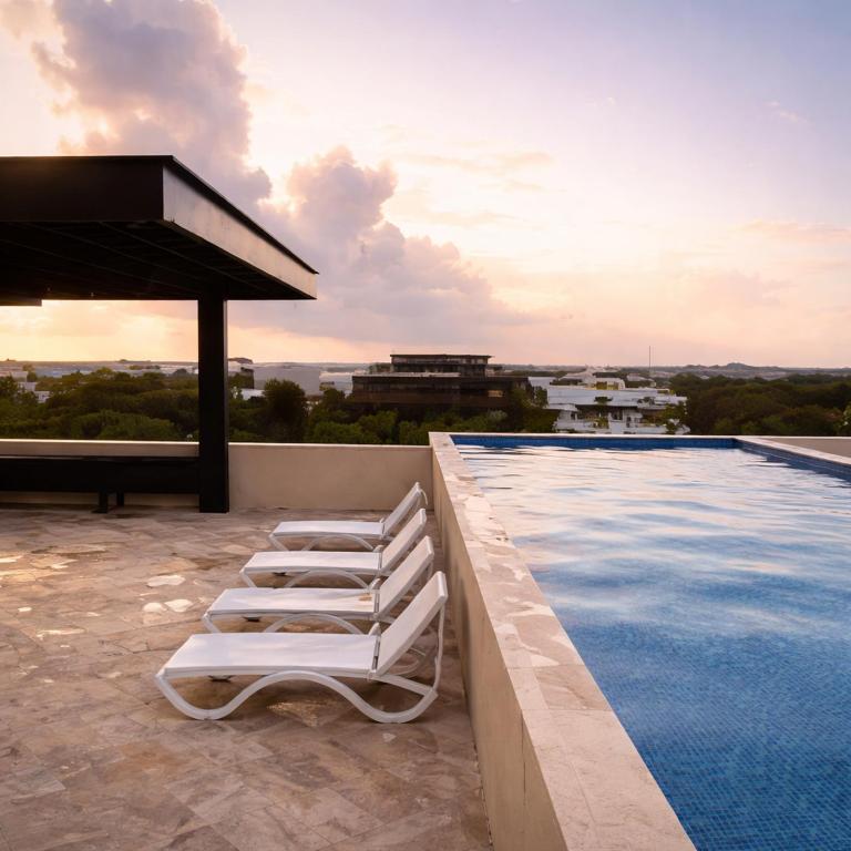 two white lounge chairs sitting next to a swimming pool at NEW 2 bed swim-up, gril with jacuzzi Aldea Zamá in Tulum