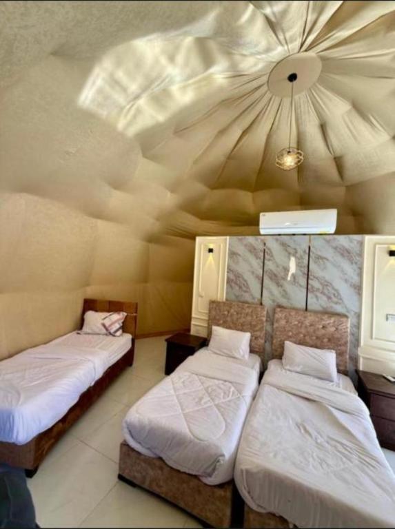 a room with two beds and a ceiling at Wadi rum lacshre in Disah