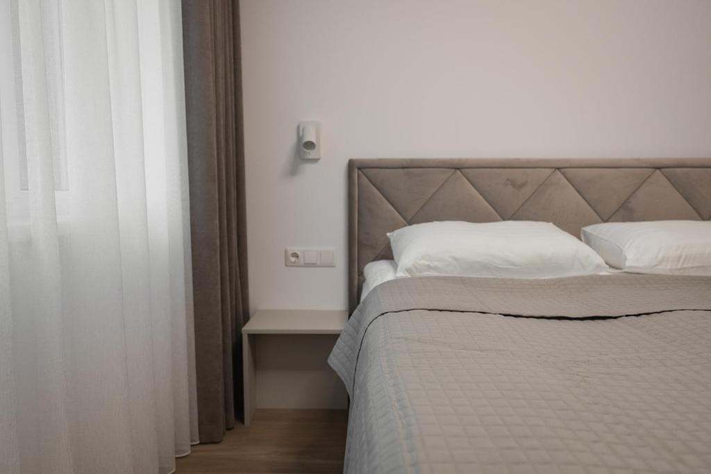 a bedroom with a bed with white pillows at 7 Levandos in Palanga