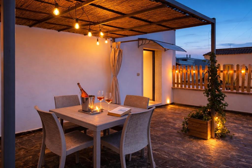 a table and chairs on a patio with a bottle of wine at Le Suite del Pastore, Monolocale con Terrazza Privata e Parcheggio Facile, vicino al Centro in Lecce