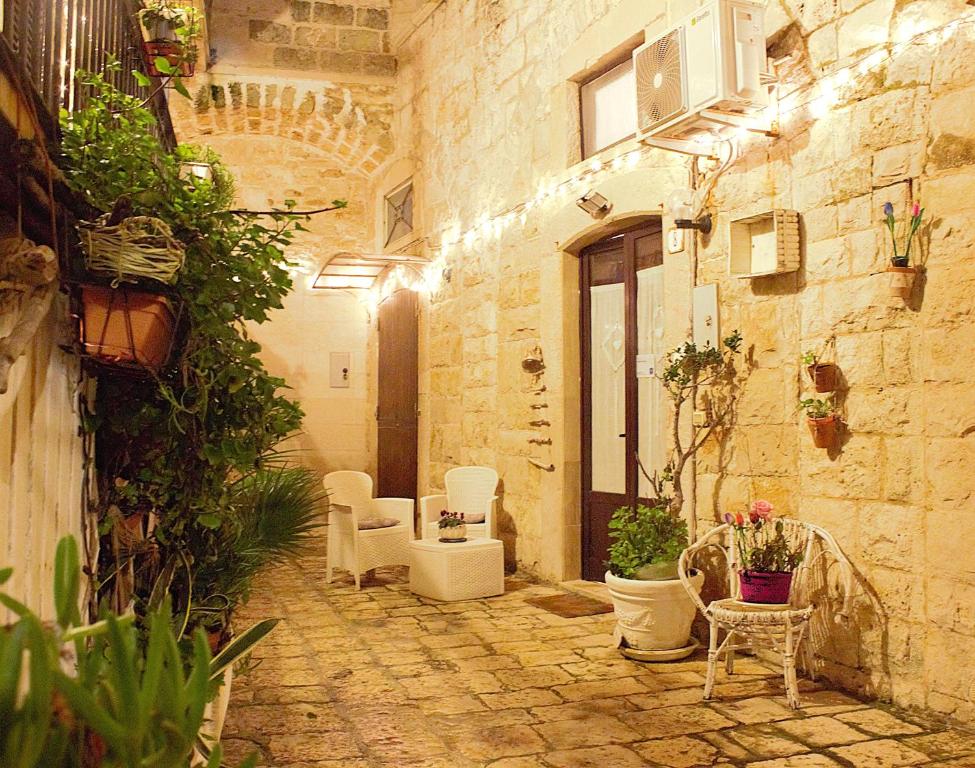 a courtyard with chairs and plants in a building at Rubini's House in Giovinazzo