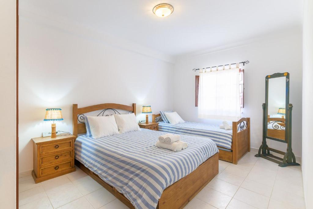 a bedroom with two beds and a mirror at Casa da Bé in Vila Nova de Milfontes