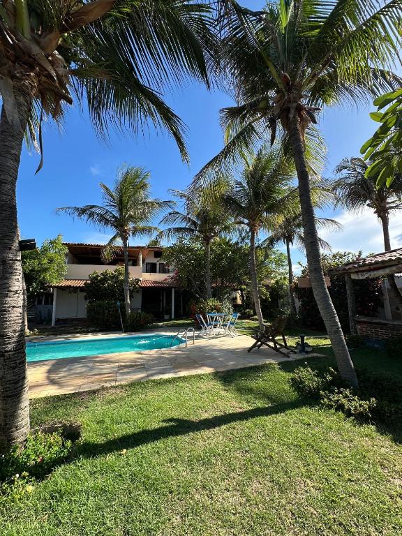a resort with a swimming pool and palm trees at Pousada Casa do Josef in Canoa Quebrada