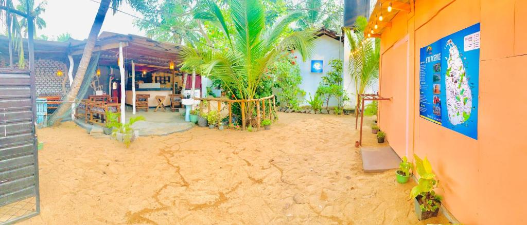 a building with a sandy floor with palm trees on it at Blue Vibe in Arugam Bay