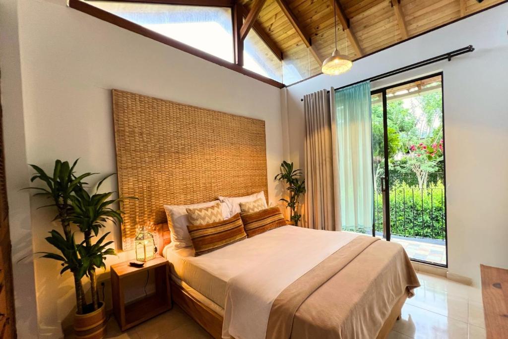 a bedroom with a bed and a large window at Casa Dornella - Casa de Hospedaje in Guaduas