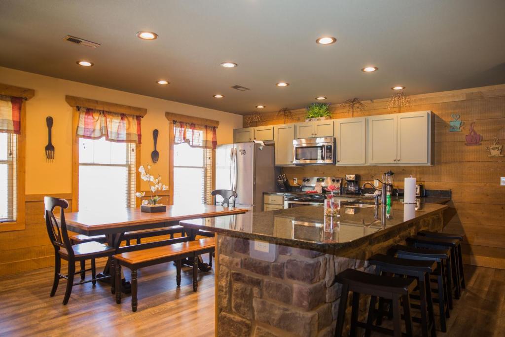 a kitchen with a counter and a table and chairs at Gatlinburg Pool Pad – Luxury 4BR Chalet, Indoor Pool, Sauna & Theater Room in Gatlinburg