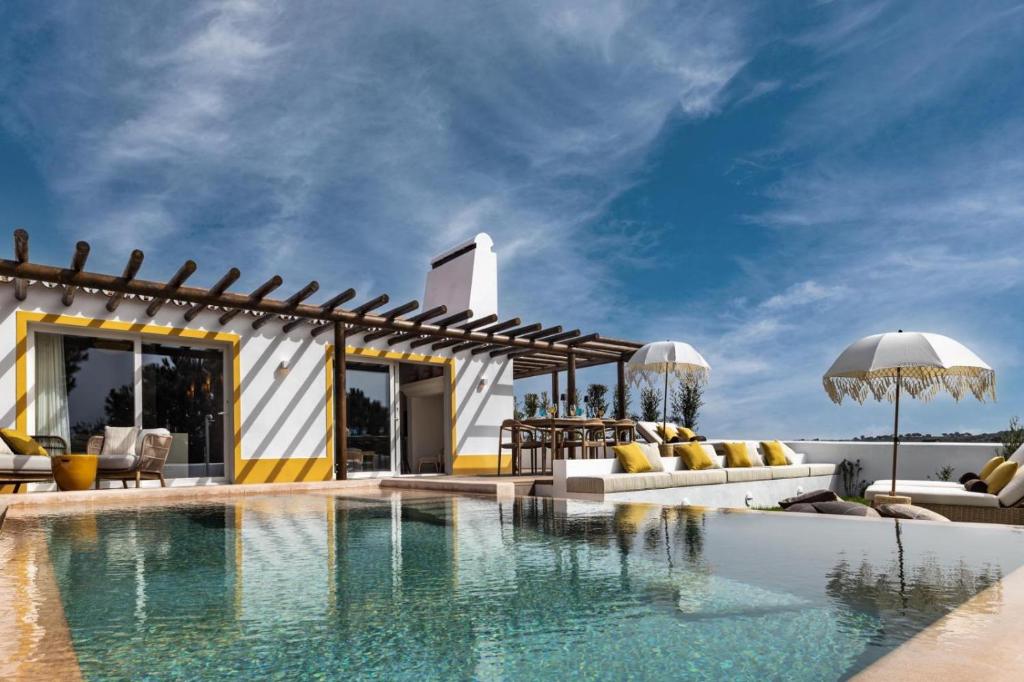 a villa with a swimming pool and a patio at Herdade do Sobroso Wine Hotel & Villas - Small Luxury Hotels of the World in Pedrógão