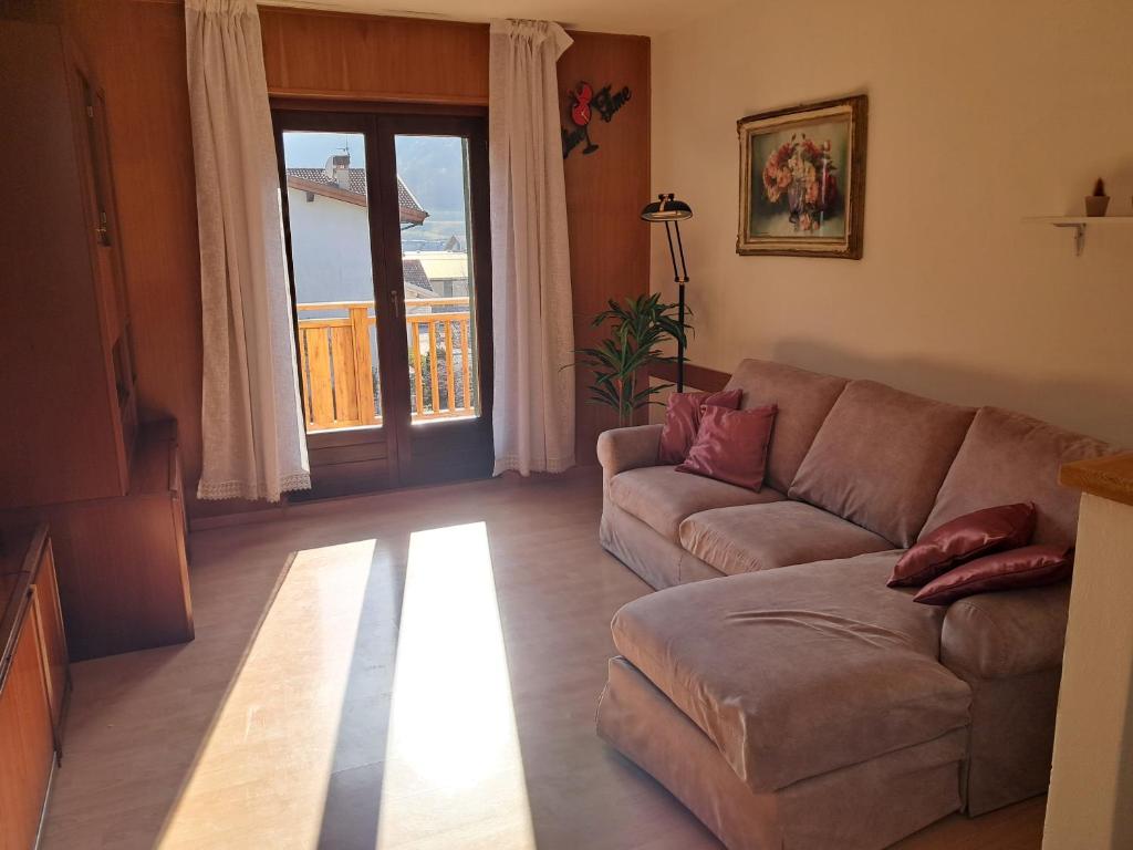 a living room with a couch and a large window at Casa Nonna Adelaide in Roncone