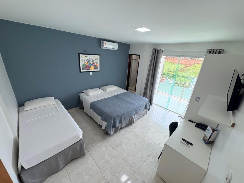 a bedroom with two beds and a television in it at Belaris HOTEL EXECUTIVO - Próximo a Praia do Calhau in São Luís