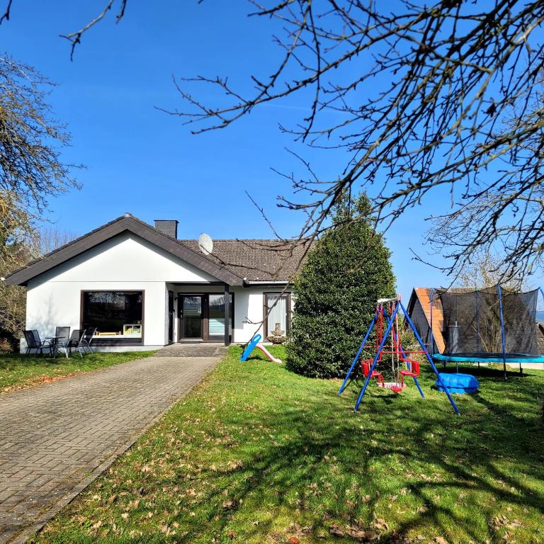 a house with a playground in the yard at Familiennest-Eifel in Blankenheim