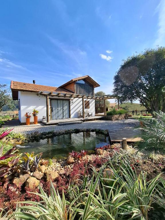 a house with a pond in front of it at Cabana Morro das Pedras in Armazém