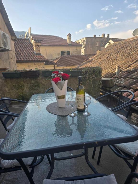 a table with a bottle of wine and a glass at Nada's room with terrace in Kotor
