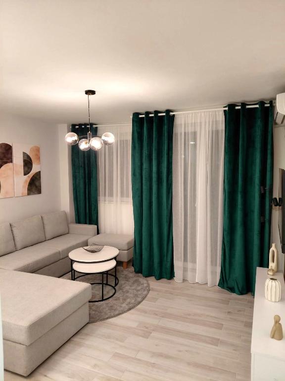 a living room with green curtains and a couch at Apartment 10 in Inđija