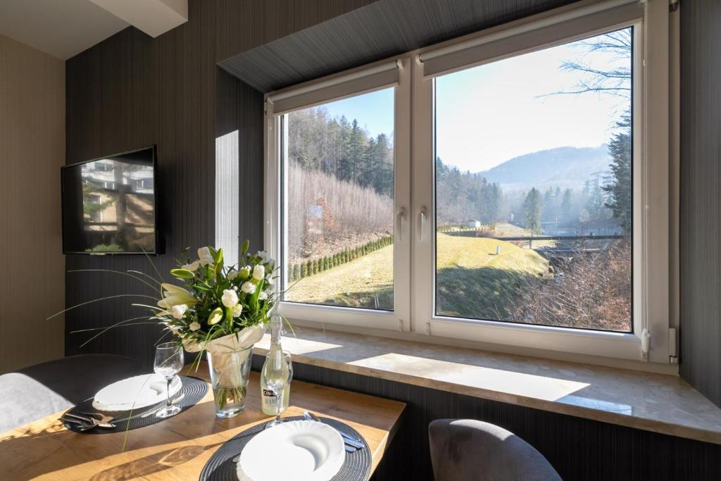 a dining room with a table and a large window at Kurort Kozubnik Daglezja D23 Vista Stay in Porąbka