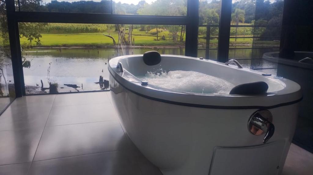 a bath tub in a room with a window at Verde Vale in Nova Petrópolis