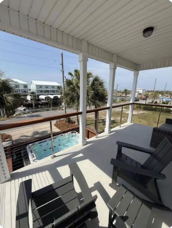 a porch with two chairs and a swimming pool at Simply Adventurous in Mexico Beach