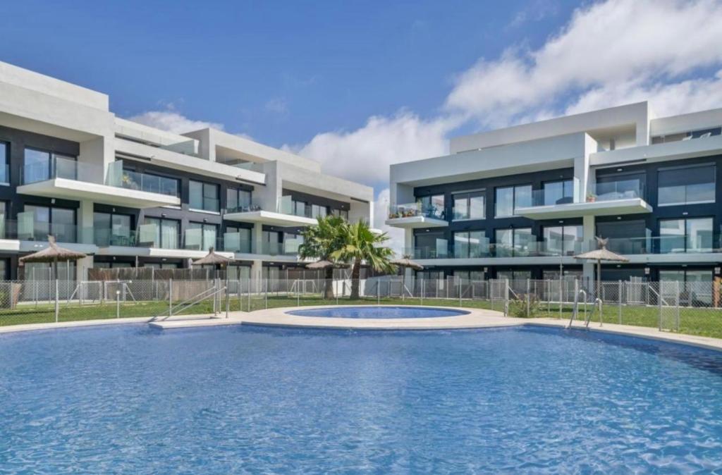 a building with a swimming pool in front of a building at Zahareña Zen House - Ático Duplex in Zahara de los Atunes
