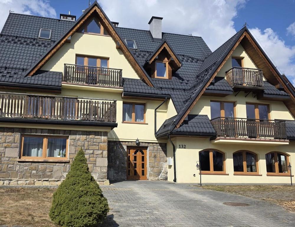 a large house with a black roof at La Kozica in Kościelisko