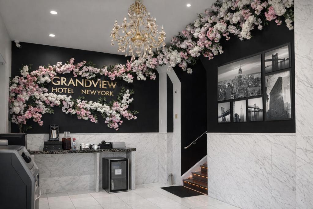 a lobby with a chandelier and flowers on the wall at Grandview Hotel New York in Queens
