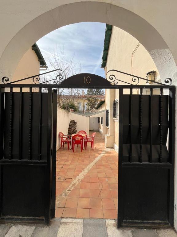 an open door to a patio with red tables and an umbrella at La Morada del Jucar in Cuenca
