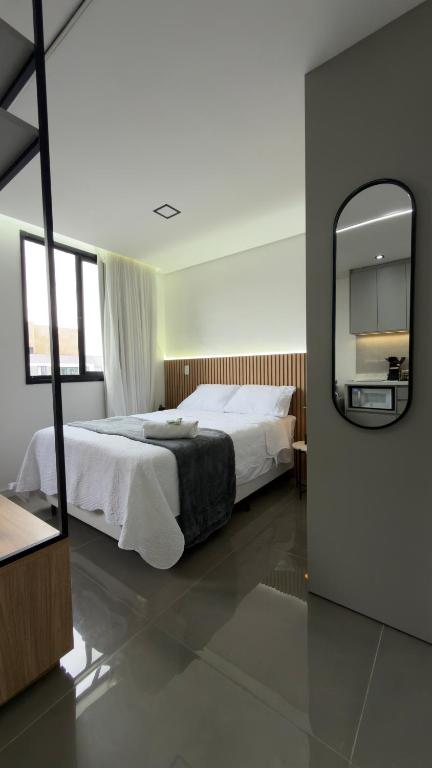 a bedroom with a large bed and a mirror at Studio - Quaddra Butantã NOVÍSSIMO MODERNO - Academia - Piscina - 5min Metrô e USP in São Paulo