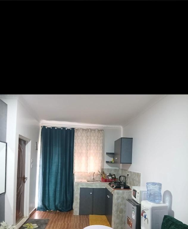 a kitchen with a blue curtain and a kitchen with a counter at Jjhomes in Eldoret