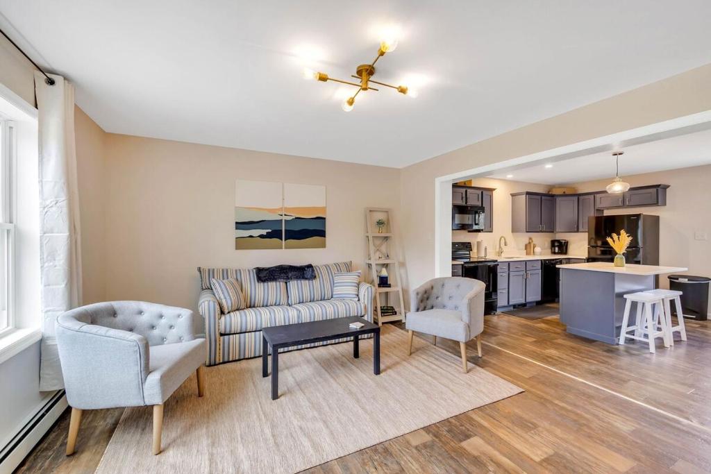 a living room with a couch and chairs and a kitchen at Coastal Maine Escape in Ellsworth