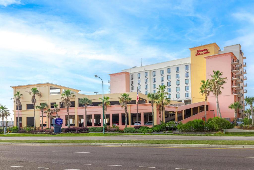 a hotel with palm trees in front of a street at Hampton Inn & Suites - Orange Beach in Orange Beach