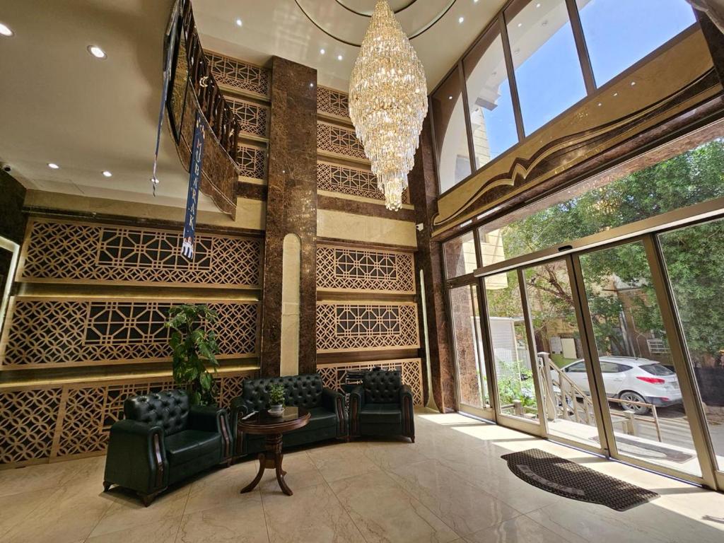 a living room with black furniture and a chandelier at Al-Mahasen Hotel in An Najaf
